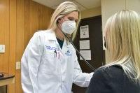 Laura E. Glueck, DO examines a patient